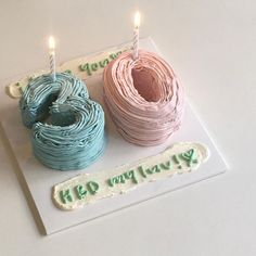 two birthday cakes with candles on top of them