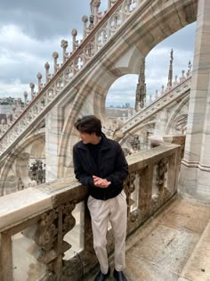 a young man standing on top of a bridge