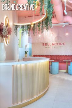 the interior of a nail salon with plants hanging from the ceiling and chairs around it