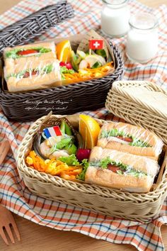 two wicker baskets filled with sandwiches on top of a table