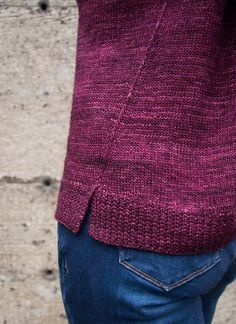 a close up of a person wearing jeans and a sweater with buttons on the back