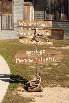 a wooden sign sitting on the side of a road