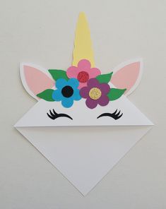 a paper unicorn head with flowers on it