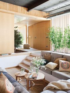 a living room filled with lots of furniture and wooden walls next to a planter