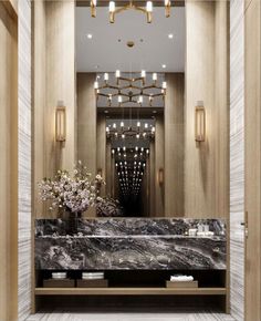 an elegant bathroom with marble counter tops and gold chandelier hanging from the ceiling