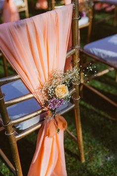 an orange sash draped over the back of a chair with flowers and baby's breath