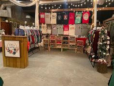 a room filled with lots of t - shirts and other items on display at the store