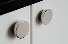 two round knobs are on the white cabinet doors