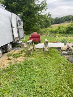 a trailer parked next to a picnic table and chair in the grass near a fire hydrant