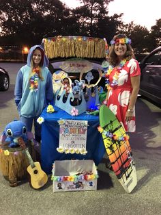 two women standing next to a table with decorations on it