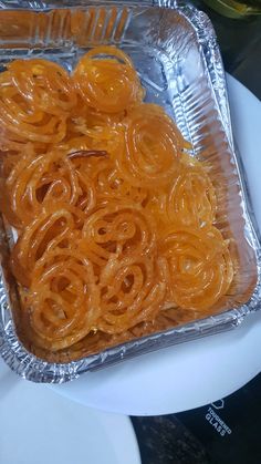 there are many pieces of food in the foil trays on the table, ready to be eaten