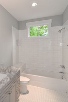 a white bathroom with two sinks and a bathtub