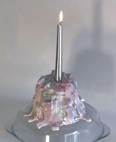 a candle that is sitting on top of a glass stand with an angel figure on it