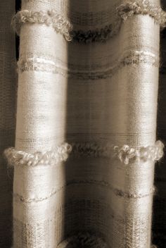 three rolls of white fabric are stacked on top of each other in black and white