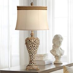 a lamp sitting on top of a table next to a busturine