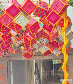 colorfully decorated umbrellas hanging from the ceiling in front of an entrance to a building