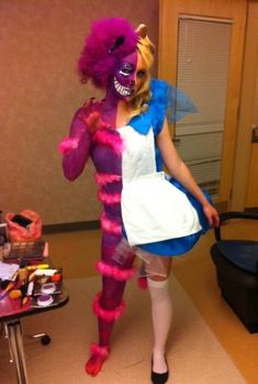 a woman dressed in costume standing next to a table