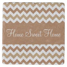 a brown and white chevroned tile with the words home sweet home on it