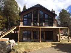 a large house sitting on top of a lush green hillside