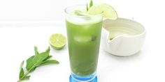 a glass filled with green liquid next to a bowl