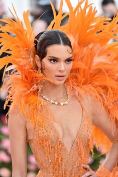 a woman in an orange feathered dress