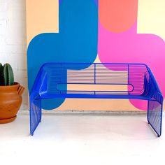 a blue bench sitting next to a potted cactus