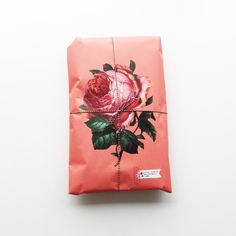 a wrapped gift with a pink rose on it