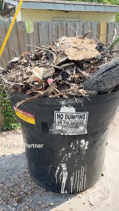 a black trash can with no dumping sign on it