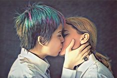 two people with colored hair are kissing each other