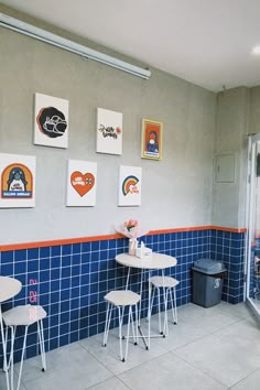 two tables and chairs in a room with blue tiles