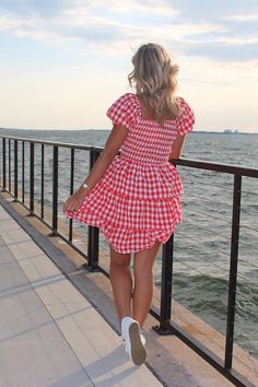 Lizzy is our newest LOVE! Look at this dress, it screams all things Summer, and Americana! Unleash your summer adventures in this trendy and playful MINI DRESS! With a charming SQUARE NECK and flattering SMOCKED BODICE, this dress will have you looking effortlessly stylish. The TIERED design adds a fun and unique touch to this red and white gingham dress. Model is 5'7 wearing small- runs true to size The red gingham • Fabric: - SELF: 97% POLYESTER 3% SPANDEX - LINING : 100% POLYESTER Gingham Smock Dress, Cute Mini Sundress For The Beach, Cute Mini Sundress For Beach, Flirty Summer Mini Dress For Picnic, Flirty Mini Dress For Summer Picnic, Cute Summer Mini Dress For Vacation, Mini Sundress With Ruffles For Picnic, Cute Square Neck Mini Dress For Day Out, Summer Red Mini Dress For Picnic