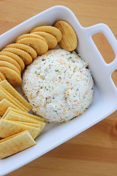 a bowl with crackers, cheese and crackers in it on a wooden table