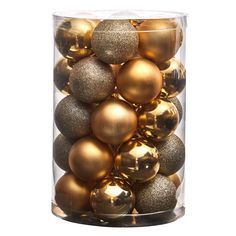 a glass container filled with gold and silver christmas baubles on a white background