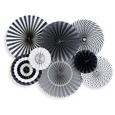 several black and white paper fans hanging on the wall in front of a white background