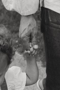 a man holding the hand of a small child