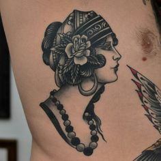 a close up of a person's stomach with tattoos on it and a bird in the foreground