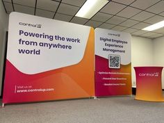 an office cubicle with two large signs on the wall and one sign that says, powering the work from anywhere world