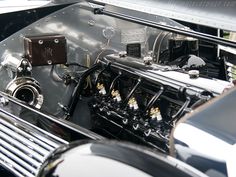 the engine compartment of an old car is shown in black and silver colors with chrome trim