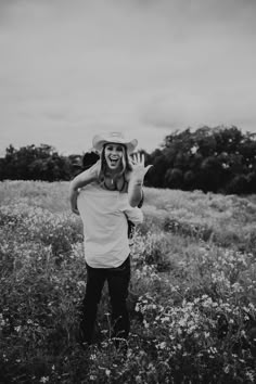 black and white photograph of a woman in a field with her hat covering her face