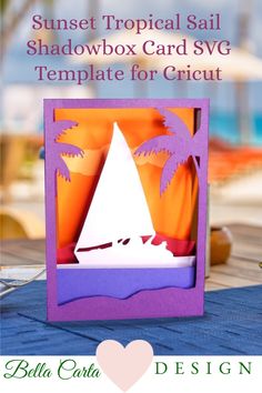 an origami card with a boat and palm trees on the beach in front of it