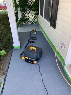 a black and yellow vacuum on the side of a house