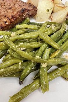 some green beans and meat on a white plate