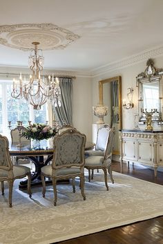 an elegant dining room with chandelier and table in the middle of the room