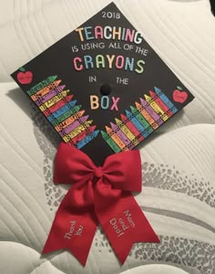 a graduation cap with the words teaching is using all of the crayons in the box