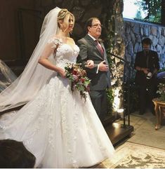 the bride is walking down the aisle in her wedding dress and groom are looking on