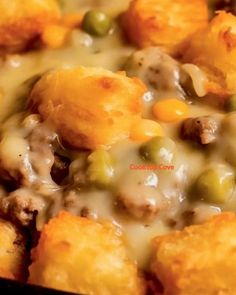 a casserole dish with tater tots, peas and cheese on it