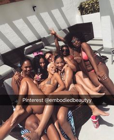 a group of young women sitting next to each other on top of a swimming pool