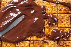 chocolate spread on crackers with a knife in the foreground and peanut butter squares to the side