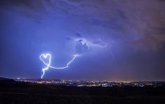 a lightning bolt is seen in the sky over a city