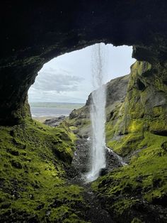 a waterfall is coming out of the cave